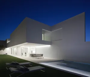 A modern exterior building with concrete walls and a glass door.