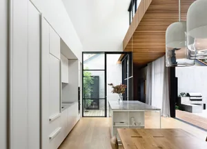 Modern kitchen and dining area featuring wood, glass, marble, and white materials.
