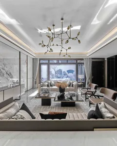 A modern living room featuring plush beige sofas, a black coffee table, and a stylish chandelier with glass globes hanging fr