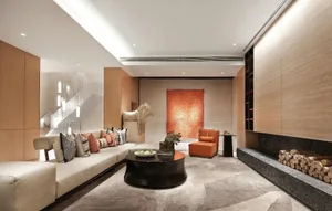 Modern living room featuring a white sectional sofa adorned with patterned and orange throw pillows, an orange armchair, a bl