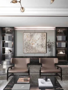 Modern living room with a marble coffee table, leather chairs, and abstract art.