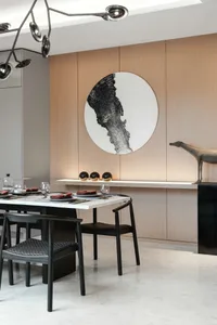 A modern minimalist dining room with wooden walls, marble table, and metal chairs.