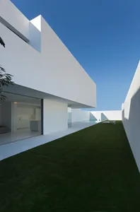 Modern, white, concrete residential exterior with a minimalist design.