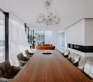 Contemporary living room featuring wooden furniture, white walls, and large windows.