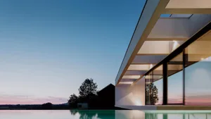 Modern residential pool house exterior with glass walls and concrete structure.