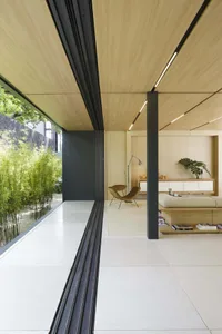 Modern living room featuring minimalist design with wood paneling and white floor.