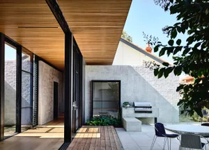 Modern residential exterior featuring concrete, glass, and wood elements.
