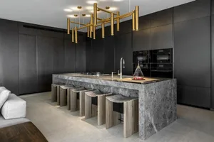 A modern, minimalist residential kitchen featuring a marble countertop and minimalist design elements.