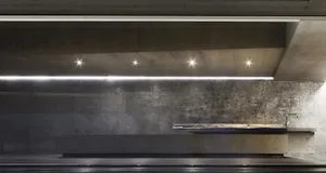 A minimalist modern bathroom with concrete walls and flooring.
