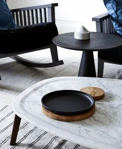 Modern interior design featuring marble tables and black wooden chairs.