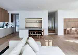 Modern living room and kitchen with open-concept design, featuring wood and marble materials