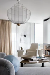 Modern living room featuring textured light fixtures, fabric upholstered furniture, and neutral color palette.