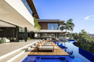 A modern living room with a pool, featuring wooden elements and a large glass wall.