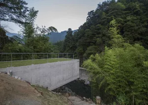 A modern outdoor architectural structure made of concrete and glass.