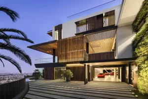 Modern house exterior featuring natural wood, glass, and metallic elements.