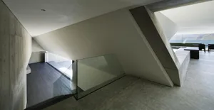 Modern interior design featuring a minimalist concrete and glass structure.