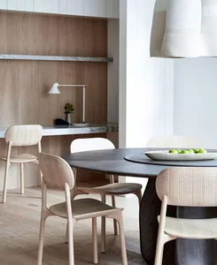 Modern dining room with wooden furniture and a round table.