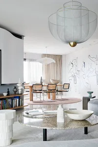 A modern living room featuring a granite coffee table, ceramic bowls, and metal lampshades.
