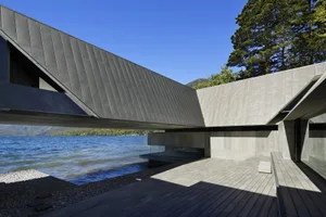 Modern residential architecture with concrete exterior near a lake.