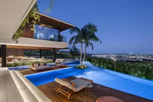 A modern residential pool deck featuring wood, concrete, and lighting elements.
