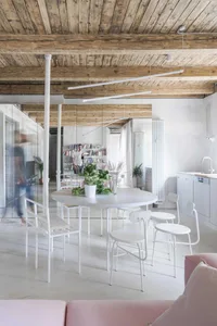 Living room with minimalist style, featuring white steel furniture and concrete floor.