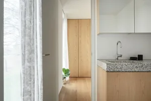 A modern kitchen with a terrazzo countertop and camera lens decor.
