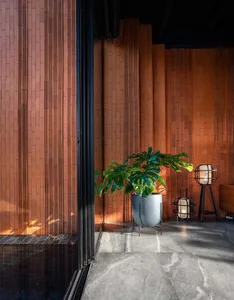A modern living room featuring wooden brick walls and a large, leafy plant.
