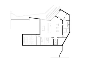 Black and white architectural drawing of an office layout with a desk, chairs, and computer monitor.