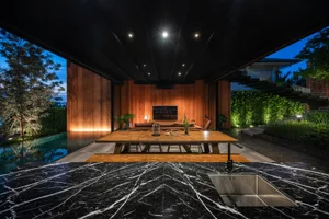 A modern outdoor living space with wooden accents and a large table.