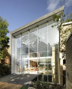 A modern house exterior featuring large glass panels creating a minimalist and sleek design.
