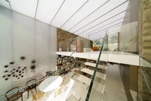 An elegant, contemporary interior design featuring a glass roof and modern furniture.