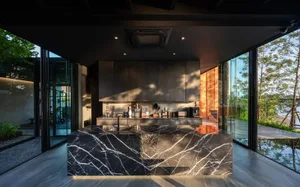 Modern kitchen featuring a marble countertop and island in a minimalist design.