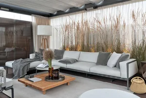 A modern living room featuring a white couch with gray pillows, a wooden coffee table, and floor-to-ceiling curtains with ree