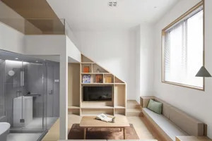 A modern loft interior with a wooden floor, glass shower enclosure, and a wooden bench with a green cushion.