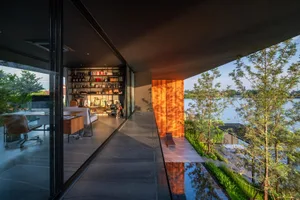 Modern office space featuring glass walls, concrete floor, and wooden accents.