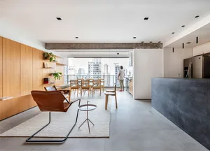 A modern open-concept living space featuring hardwood flooring, concrete elements, and glass doors.