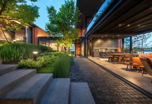 A modern residential exterior with a landscaped garden featuring concrete steps and greenery.