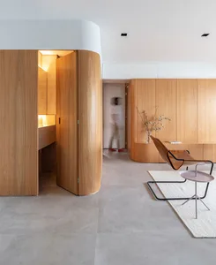 A modern residential interior featuring wooden cabinets and concrete floors.