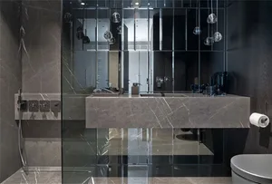 Modern bathroom with marble sink and floor, featuring a minimalist design with a glass shower enclosure.