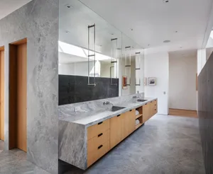Modern bathroom with marble countertop and large mirror.