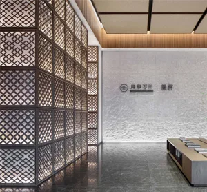 Modern office entryway with a middle gray matte black floor and a lattice wall with a light fixture.