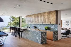 A modern kitchen with a marble island and ample seating.