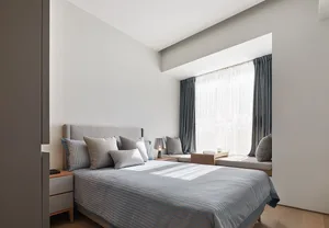簡約臥室內，床上鋪著灰白條紋寢具，搭配灰色枕頭，窗戶上掛著窗簾