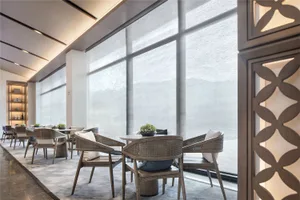 A modern cafeteria with fabric seating and wooden tables.