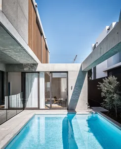 Modern residential architecture featuring a concrete pool and patio area.