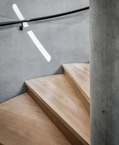 Modern industrial-style staircase with concrete walls and wood treads.
