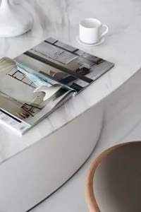 White modern interior design magazine cover with architectural imagery and a white teacup on a marble surface.