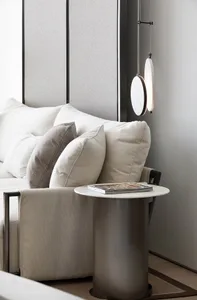 Modern, minimalist living room with a white sofa, pillows, and a side table.
