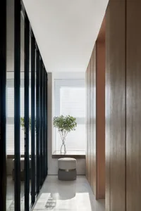 Modern interior design featuring a glass corridor with white flooring and a potted plant.
