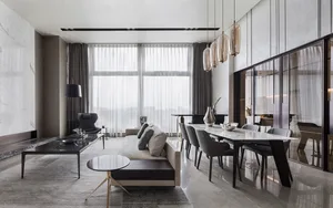 Modern living and dining room featuring marble finishes and sleek furniture.